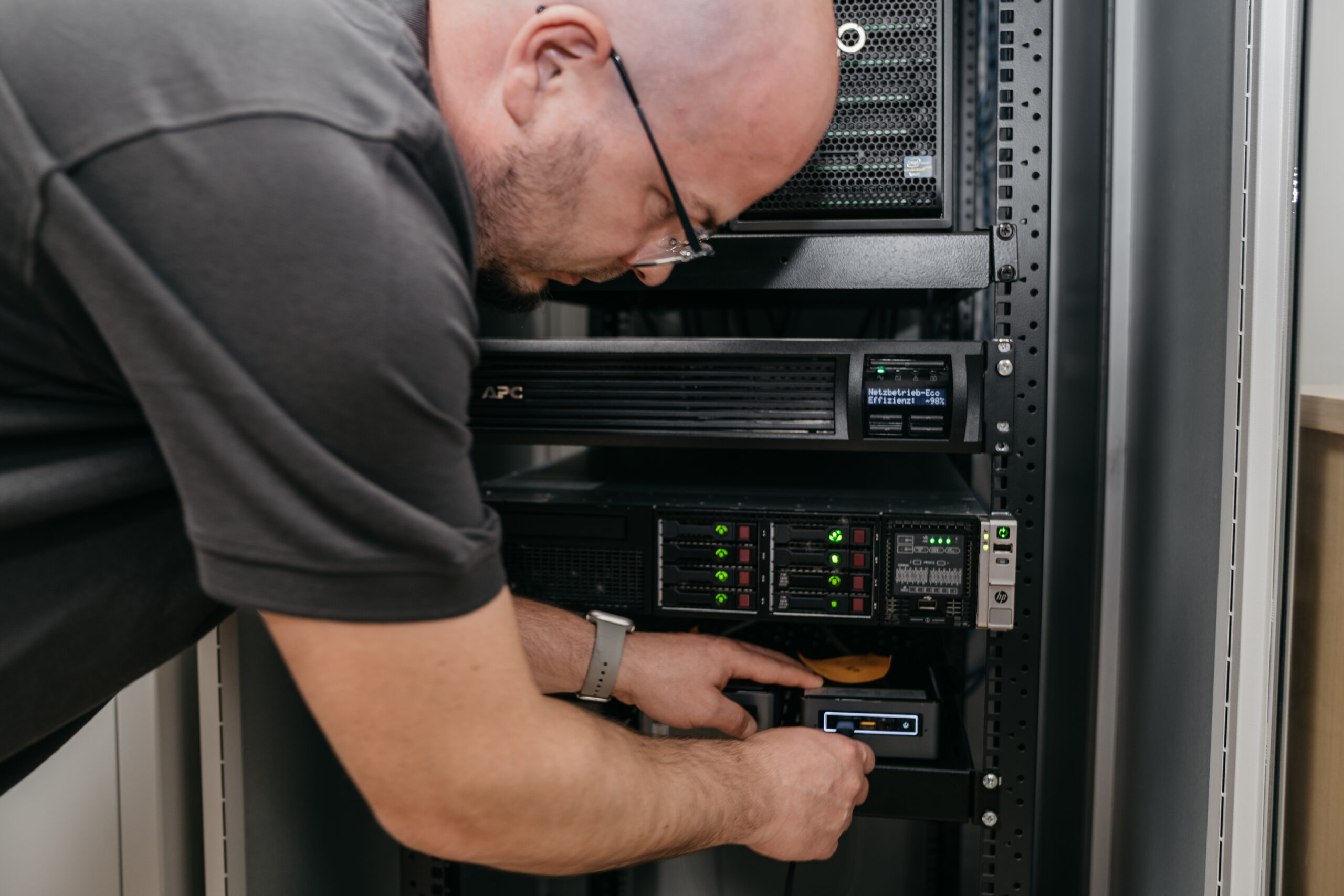 Techniker, der an einem Server-Rack arbeitet und eine Komponente einsetzt.